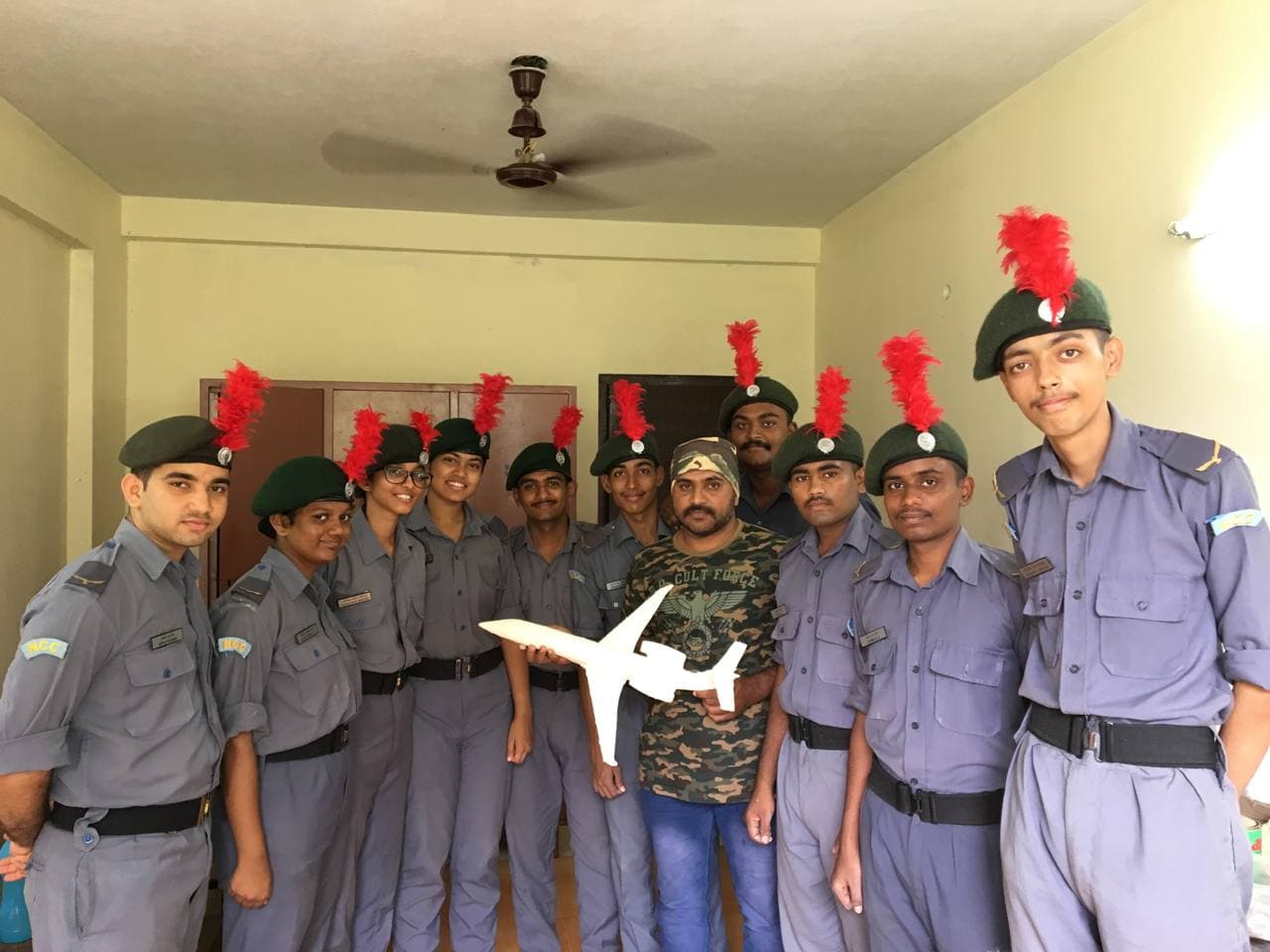 "NCC cadets learning to build a static model of an Embraer aircraft during an aeromodelling workshop."