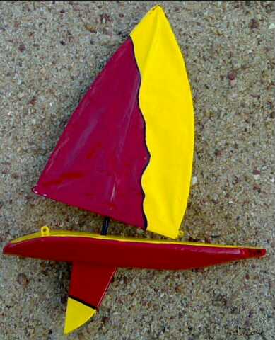 Red and yellow model yacht designed for sailing and hobby enthusiasts.