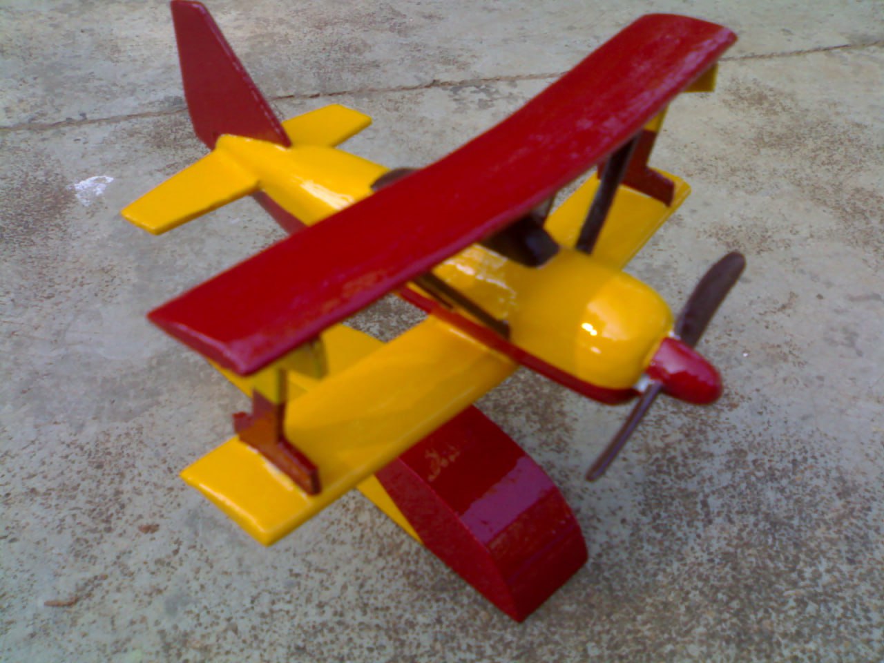 Handcrafted red and yellow biplane static model with intricate details.